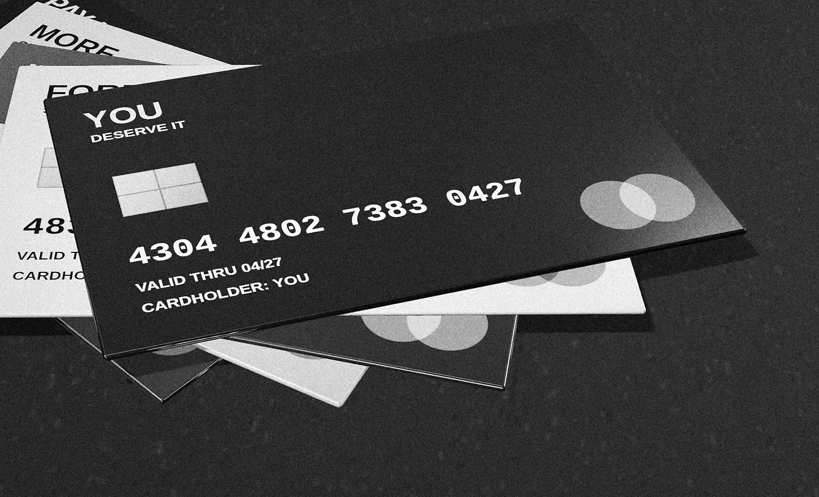 Black-and-white photograph of a fan of credit cards named PAY LATER, MORE and YOU DESERVE IT.