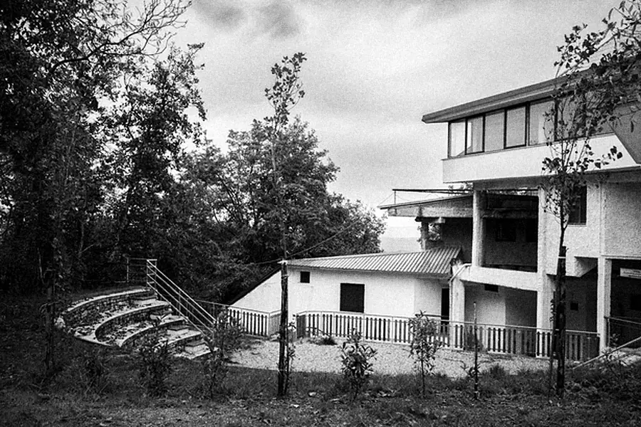 The main building with terraces and a stone amphitheatre in front.